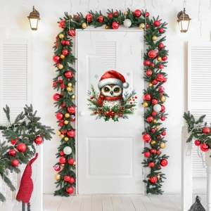 Détail d'un autocollant chouette de Noël avec bonnet rouge et écharpe sur une porte