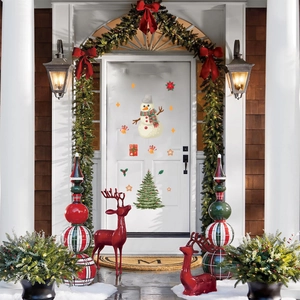 Detailed view of Christmas snowman and tree static stickers on a white front door