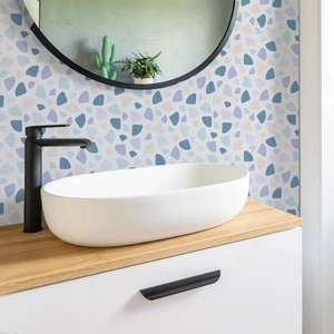 Modern oval white ceramic countertop sink with matte black faucet and pebble wall