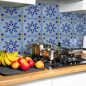 Close-up of blue and yellow Moroccan tile stickers on a kitchen backsplash with pans