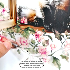 Close-up of removable floral sticker being peeled showing adhesive backing and durability