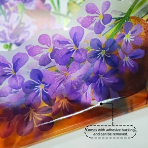 Detail of floral wall sticker showing adhesive backing and removable glossy finish