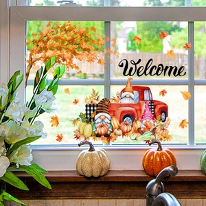 Close-up of autumn window decals featuring a red truck, gnomes, and welcome sign decor