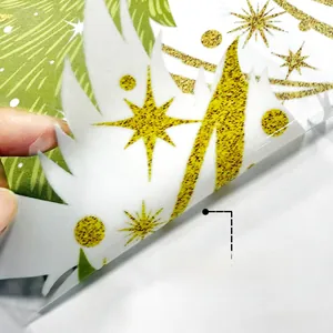 Close-up of double-sided Christmas tree window sticker with glittery stars and patterns