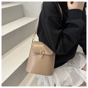 Détail d'un sac seau en cuir minimaliste avec boucle en or sur le mannequin