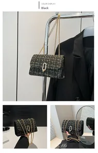 Macro view of black tweed fabric texture and gold buckle on a chic chain shoulder bag