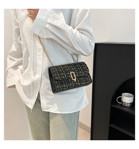 Détail du sac bandoulière en tweed noir classique avec chaîne dorée et fermoir en métal