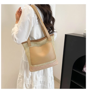 Detailed view of woven straw tote bag with leather pocket and pink base detail