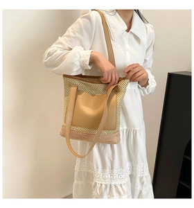 Detail of straw tote bag with leather straps and pastel pink woven color block