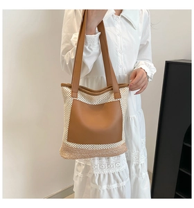 Detail of white mesh woven tote bag with brown leather handles and decorative pocket