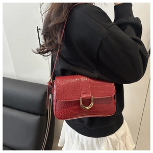 Vue détaillée du sac rouge foncé à motif crocodile avec boucle dorée en forme de D