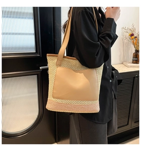 Detailed view of woven tote bag with pink gradient base and leather patch pocket