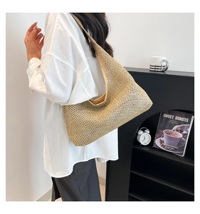 Detail of a beige woven straw underarm bag featuring a hollow mesh design and soft texture