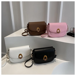Sacs de selle en marron, rose, blanc et noir avec boucles dorées en U sur présentoirs