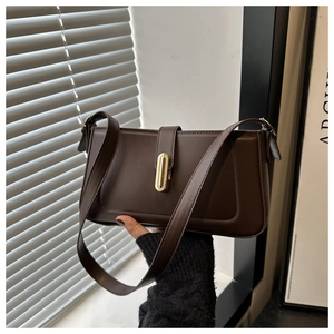 Détail d'un sac d'épaule en cuir marron foncé avec boucle métallique rectangulaire dorée
