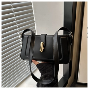 Détail du sac sous l'aisselle en cuir noir avec coutures en U et boucle dorée