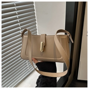 Détail du fermoir en métal doré sur un sac baguette en cuir synthétique crème