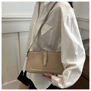 Detail of khaki minimalist leather shoulder bag with gold rectangular metal lock clasp