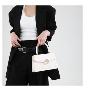 Detail of white crocodile embossed small square bag with elegant golden metal fastener