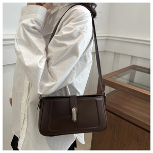 Detail view of large dark brown leather crossbody bag with a sleek gold metal buckle