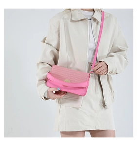 Detail showing pink leather and woven texture mix on cross-body bag with gold lock