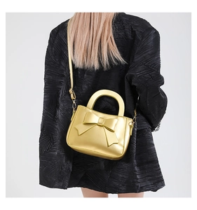 Golden bow square handbag shown on a model in a stylish crossbody wear back view