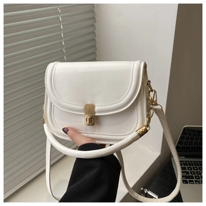 Close-up of white crossbody bag featuring a golden twist lock and textured leather finish