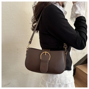 Détail du sac marron foncé montrant la boucle fer à cheval dorée et le cuir lisse