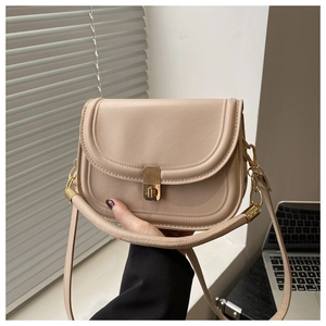 Detailed shot of beige saddle bag with gold rotating lock and premium stitching