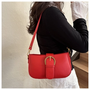 Détail macro du sac sous les bras rouge avec une boucle en métal doré de style vintage