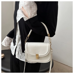 Detailed texture of white leather crossbody bag with elegant gold metal lock and chain