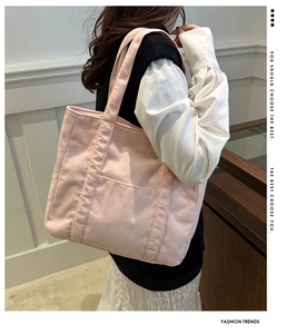 Detail of pink corduroy tote bag featuring external pocket and soft ribbed texture