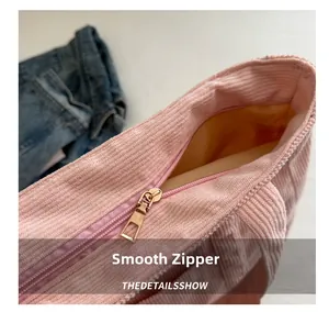 Detail of pink corduroy tote bag featuring smooth gold metal zipper and soft yellow lining