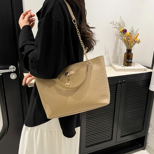 Beige tote bag with woven texture, golden chain strap, and cute deer charm on model