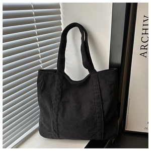 Detail showing soft corduroy texture and sturdy straps of a black large tote bag