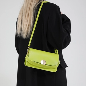 Sac bandoulière carré en cuir vert néon avec boucle dorée sur mannequin en noir