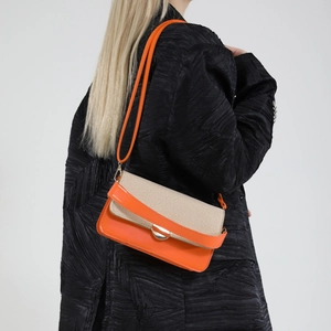 Orange leather and beige fabric crossbody bag with gold buckle on shoulder