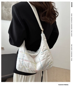 Close-up of white quilted shoulder bag with multicolor stitching and puffer nylon texture