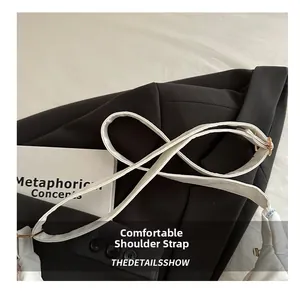 Detail of wide white leather shoulder strap with adjustable gold buckle for tote bag