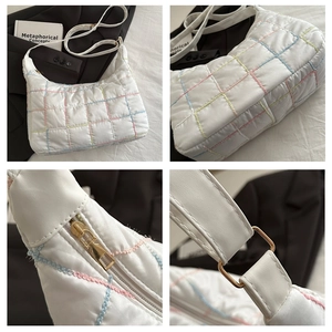 Macro detail of white quilted hobo bag with colorful stitching and gold hardware