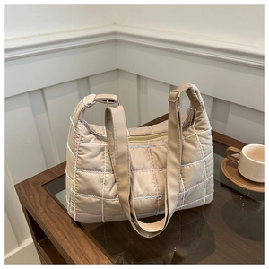 Close-up of beige quilted hobo bag with colorful grid stitching and sleek top zipper