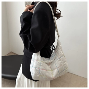 Detail of white quilted tote bag featuring colorful stitching and soft nylon texture