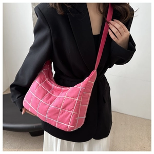 Detail of pink quilted hobo bag with grid stitching and adjustable shoulder strap