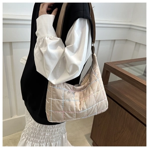 Detail of beige quilted shoulder bag with multi-color rainbow stitching and nylon texture