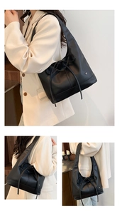 Detailed close-up of a black leather tote bag with elegant bow tie and heart logo accent