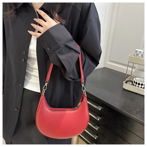 Detail einer roten Halbmond-Tasche aus strukturiertem Leder mit goldenen Haken