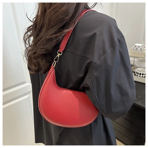 Detailansicht der roten Halbmond-Tasche aus Leder mit goldenem Metallverschluss