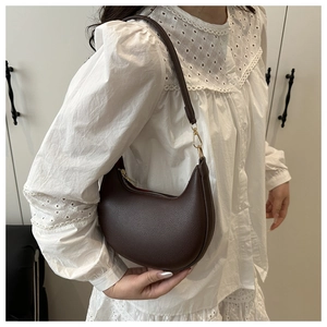 Nahaufnahme der braunen Hobo-Tasche mit Litschimuster, Goldreißverschluss und Trageriemen