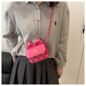 Gros plan détaillé d'un mini sac rose avec nœud décoratif et motif à pois blancs