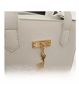 Détail du sac en cuir grainé blanc avec pendentif cerf doré et fermoir métallique